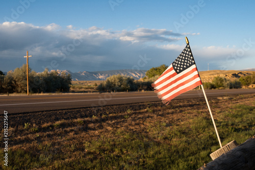 Small American flag waving in the afternoon along a highway in Utah