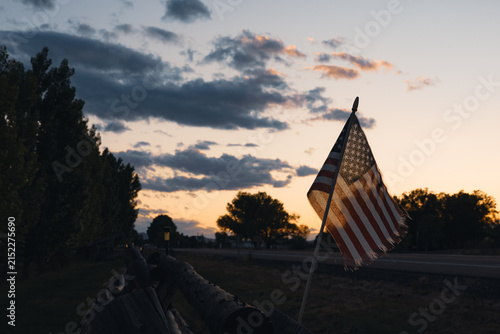 Small American flag at sunset along a highway in Utah