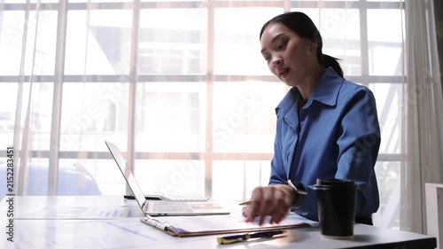 Professional Asian businesswoman discussing business strategy and presenting financial data charts to colleagues during an online video meeting.