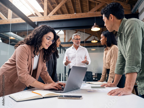 Diverse team collaborating in a modern industrial-chic office, working together on project strategy and development.