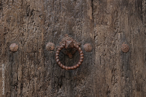 Obraz na płótnie Old rough round door knocker on old dark wooden rustic  door