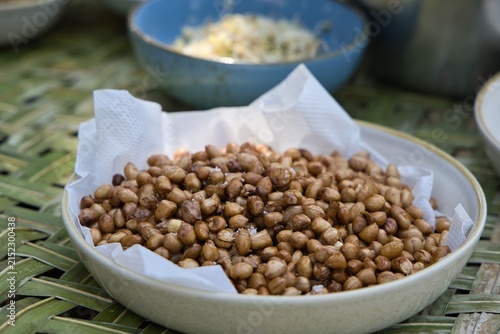 Foto Fried salted peanuts served in a ceramic bowl lined with paper, prepared as fresh ingredients during an authentic traditional culinary cooking class in Bali, Indonesia