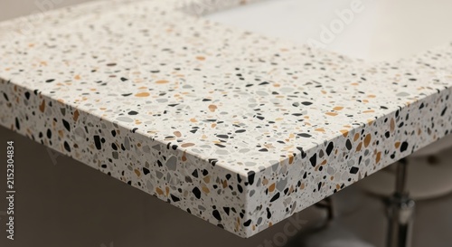 A premium bathroom vanity countertop displays durable terrazzo surfacing with crushed stone fragments integrated into resin, showcasing artisanal craftsmanship for high end residential interior