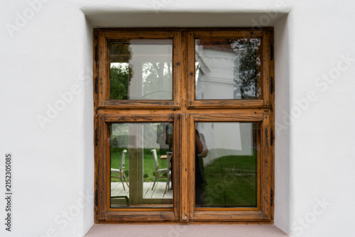 Old, renewed wooden window on a white wall close up shot.