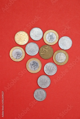 Brazilian coins arranged in the shape of Brazil map over a red background, representing Brazilian economy, inflation, and salary.