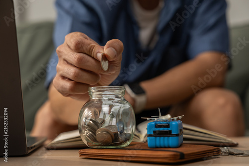 Фотография Hand coin jar saving money budget finance home wallet laptop adult hand placing