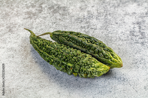 Obraz na płótnie Two green bitter gourds on textured gray surface