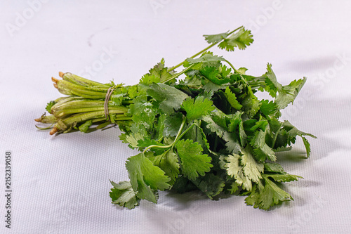 Foto Fresh cilantro bunch on white textured surface