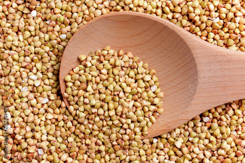 Konstfotografi Top view of raw buckwheat groats spread across a surface with a wooden spoon