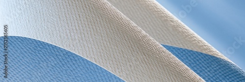 Close-up of a textured fabric with blue and white stripes, suggesting a flag or banner waving gently.