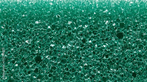 Closeup texture of a green porous cleaning sponge surface