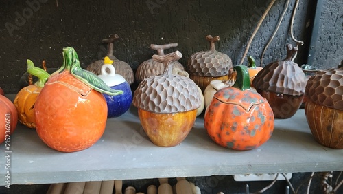 Handmade ceramic pumpkins and acorns displayed in pottery workshop