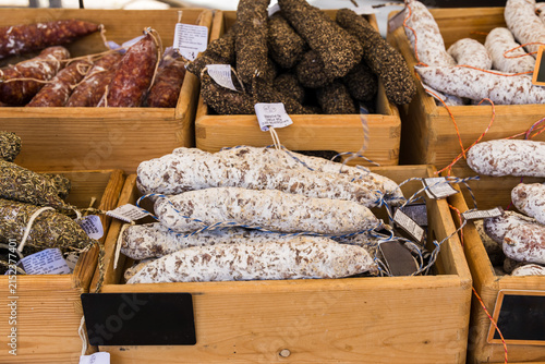 Traditional cured French sausages displayed in wooden crates at a local market, showcasing regional food, artisan products and French culinary heritage.
