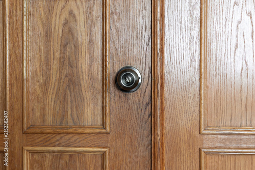 Wooden door with metal knob lock and panel design close up