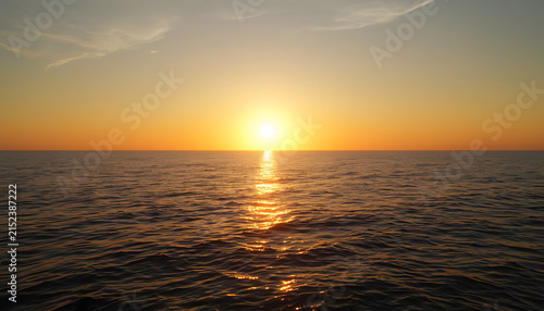 Brilliant Golden Sunset Over Calm Ocean Horizon with Warm Reflections Across the Water, Peaceful Evening Seascape