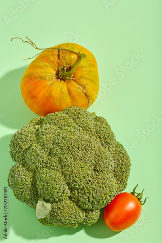 Top view composition of raw broccoli florets and ripe tomatoes