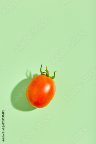 Fresh red tomato under harsh bright sunlight with shadow