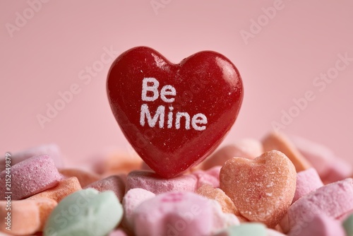 Be Mine candy resting atop tiny heart candies in a romantic still-life composition