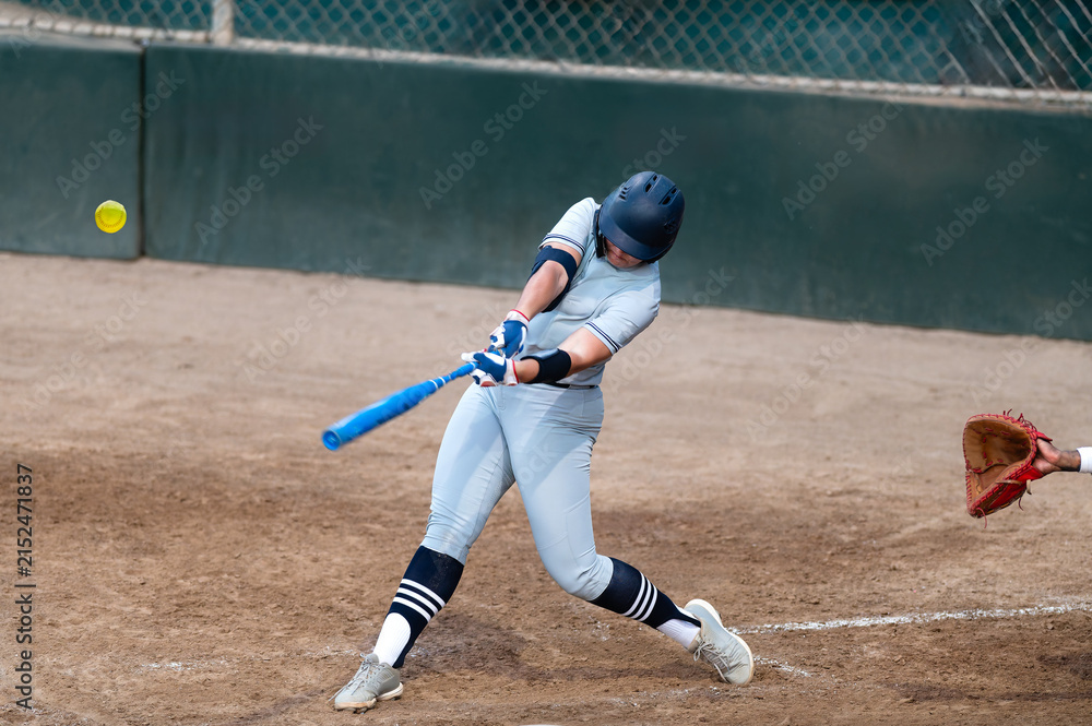 Fototapeta premium Softball Player Batting Swinging Hitting Playing Fast Pitch Baseball Action Sports