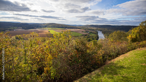 Wyalusing, Pennsylvania, USA - October 20, 2023: High-angle view of the Susquehanna River from the Wyalusing Rocks Scenic Overlook. Farmland fields and autumn colors under a partly cloudy sky.