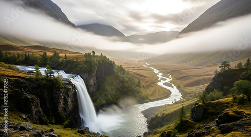 Majestic waterfall cascading into a misty valley with a winding river during dramatic overcast lighting