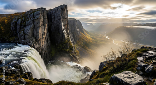 Majestic Waterfall cascading down sheer cliffs during golden hour with sunbeams illuminating distant valley landscape