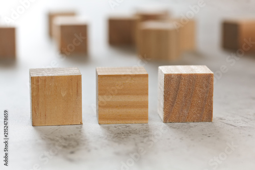 Three wooden cubes, more blurred in background