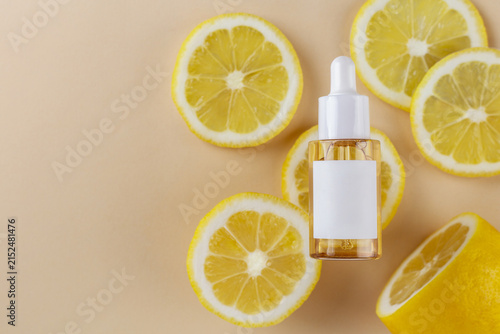 Fotografía Natural serum bottle with fresh lemon slices on a neutral background