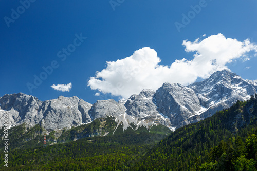 Travel landscape of Zugspitze Alps in Bavaria, Germany, scenic summer nature panorama with forest, snow mountains peak. Alpine landscape