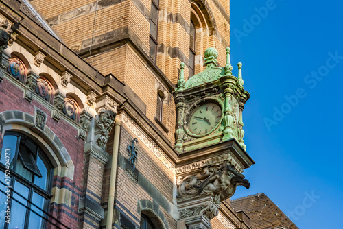 Fotografie Close up of ornamental vintage projecting clock on facade of historic building i