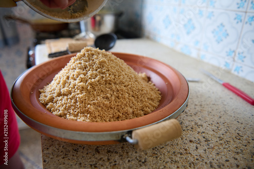 Authentic Moroccan couscous dish on a clay plate in a home kitchen preparing semolina grain