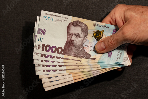 Canvas Print Hand holding fan of Ukrainian one thousand hryvnia banknotes