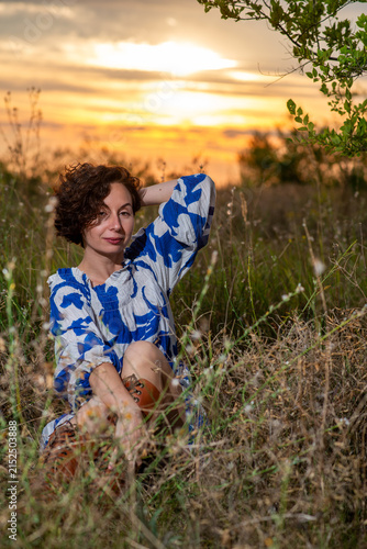 Woman Relaxing in Meadow at Sunset