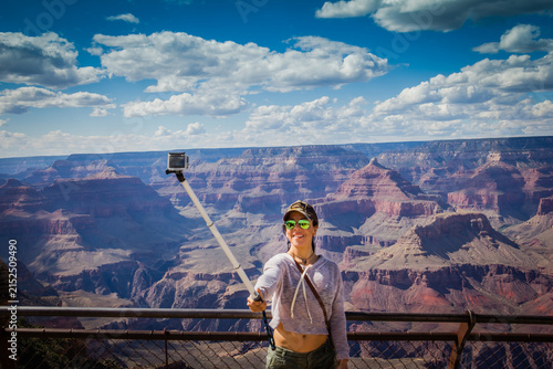 Person holds selfie stick, capturing grand canyon vista