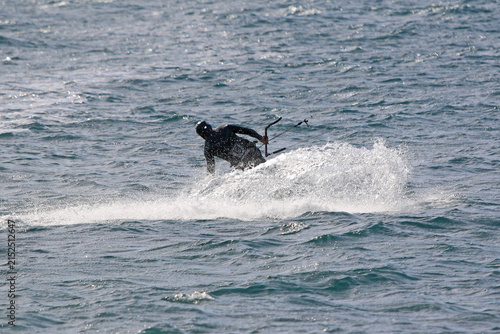 	
kitesurfer riding his board on the sea	