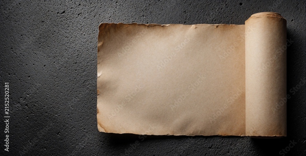 Fototapeta premium Vintage brown paper scroll with burnt edges lies on dark grey concrete texture. Old parchment roll provides blank space for text design. Minimalist background for antique message, ancient manuscript,