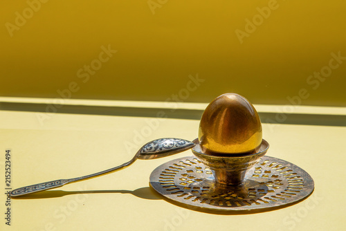 Konstfotografi Golden egg symbolizing wealth, success, and prosperity on yellow background