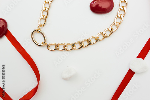 Quadro su tela Modern chunky gold chain necklace with oval lock and red ribbon on white background