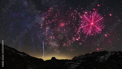 Colorful fireworks illuminate the night sky above the mountains in Switzerland with Milky way, with vibrant red green and white bursts. Alps silhouettes frame the scene as explosions reflect on calm w