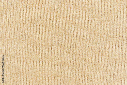 Photography A top-down view of knitted fabric showcasing its texture and pattern in beige and tan tones, fashion and textile markets