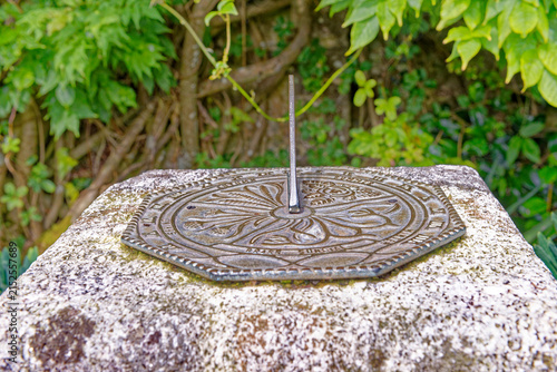 Antique Brass Sundial on Weathered Stone Pedestal in Estate Garden