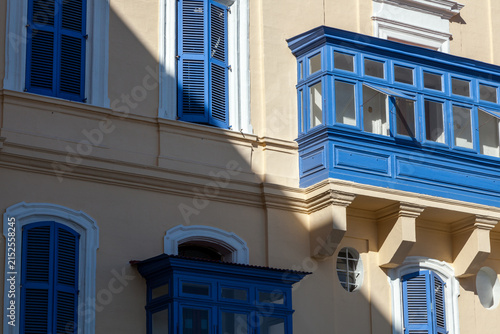 Bright blue gallarija balconies and shuttered windows stand out against a cream-coloured facade in Valletta, Malta