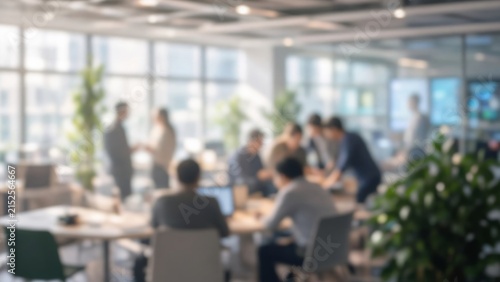 Business people working together in a blurred, contemporary open plan office, focusing on collaboration and project development