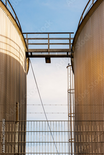 Obraz na plátně Industrial catwalk between cylindrical storage tanks