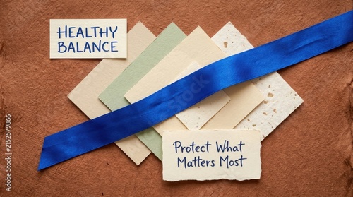 Elegant wellness composition featuring healthy balance and protect what matters most text on recycled cards with a blue ribbon over a brown textured paper background ideal for health and insurance aid