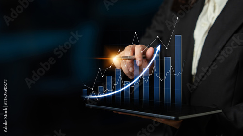 Konstfotografi A business professional demonstrates growth and success using a digital tablet featuring an upward-trending graph, symbolizing performance and strategic planning