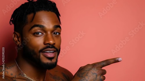 Confident young african man smiling and pointing against coral background
