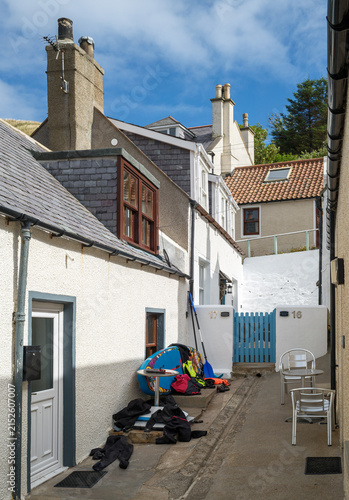 Canvastavla Surfboarder gear rests in a narrow coastal alleyway on a sunny day in the villag
