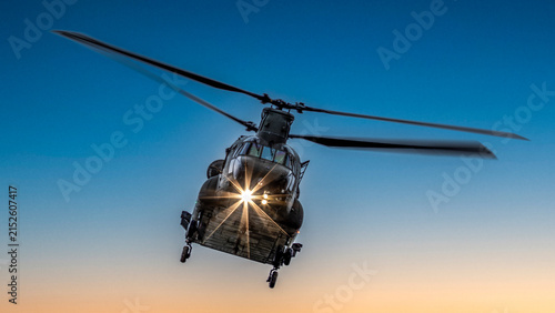 Фотография Heavy lift military helicopter flying at sunrise