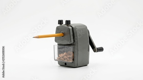 Vintage mechanical pencil sharpener with yellow pencil, retro grey metal desk accessory, classic office stationery on white background